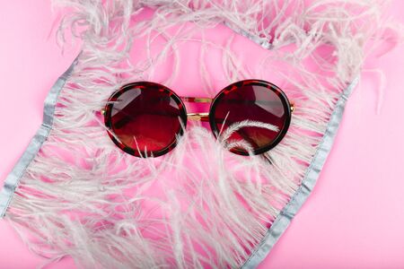 round glasses in feathers. flat lay ostrich feathers. Glamor and style. The feathers are gray. Round and ceremonial glasses. Glasses for womenの写真素材