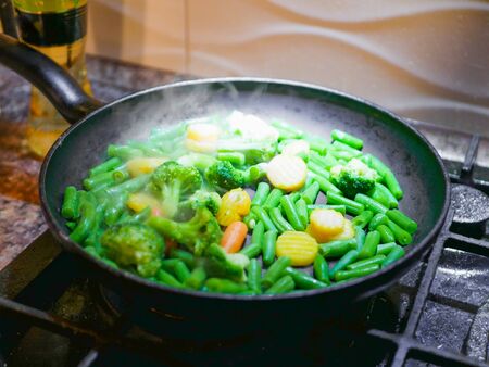 Vegetables fried in a pan close-up. Steam is coming. Defocus. vegetarian barely. Eco foodの写真素材
