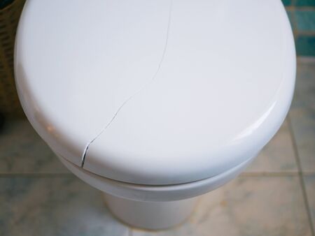 Broken toilet lid. Crack on the toilet lid. Close-up.の写真素材