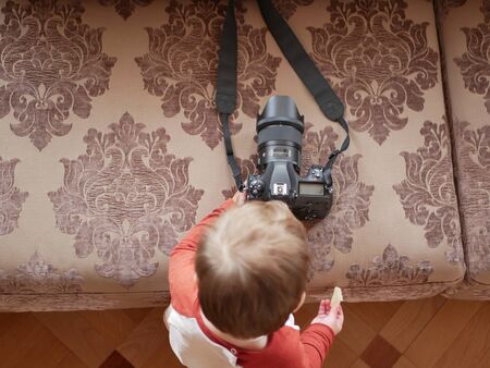 Baby boy and camera. Young photographer. Professional camera.の写真素材