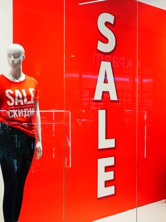 Female mannequin in a shop window on the background of the inscription saleの写真素材