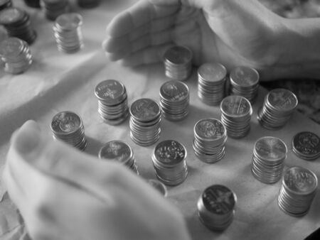 Silver coins close up. Counting savings. Tax rate. Production costs. Distribution of finance. Laid out by a column.の写真素材