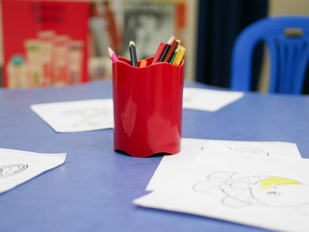 A glass with a pencil in a development center for children. Colored pencils in a glass. childrens creativity, objects for design. bright pencils on the table lightの写真素材