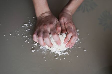 Hands wrinkle the dough close-up. Manual dough preparation. Homemade bakingの写真素材