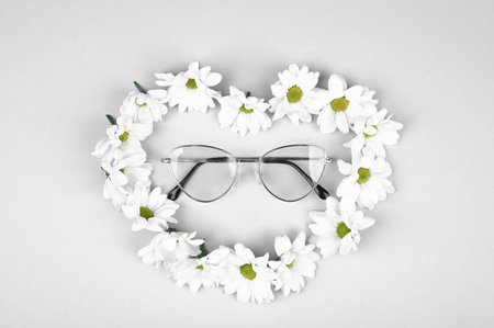 Glasses in natural colors. Glasses in daisies in the shape of a heart. Nature and glasses. flat lay....