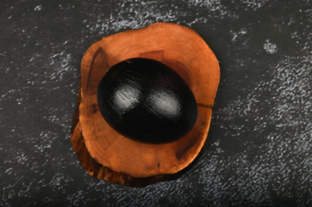 black eggs on a wooden board. flat lay. Black Easter. three black eggs.の写真素材