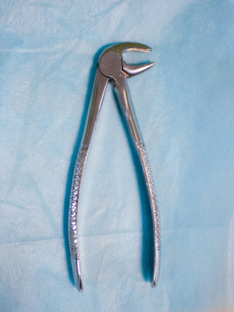 Dental tool for removing teeth. close top view. removal of a tooth. Dental Pliers, Tooth Extraction.