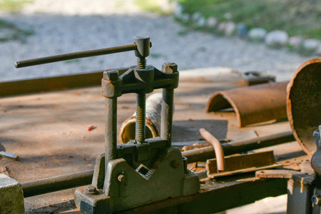 blacksmith's clamp. Metal clamping device on an old workbench. Vise desktop.