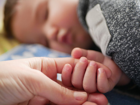 mom holds the baby's hand close-up. child 0-1 years old.の写真素材