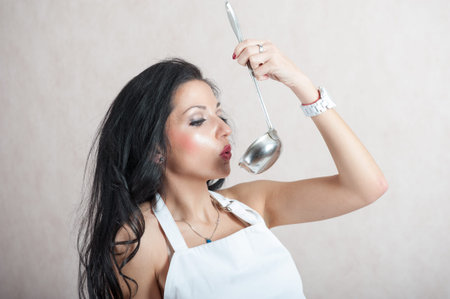 girl blowing in the kitchen scoop. portrait of a girl with a scoopの写真素材