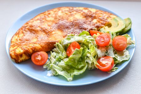 Fresh vegetables with scrambled eggs. on a round plate. Omelet with mushrooms.の写真素材