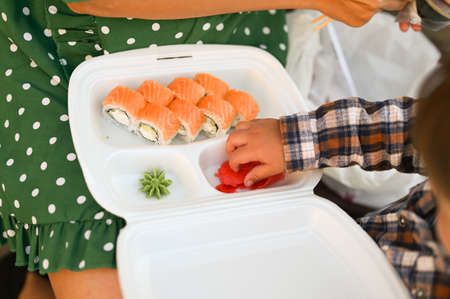 Mother with baby eat sushi on the street on the street. High quality photoの写真素材