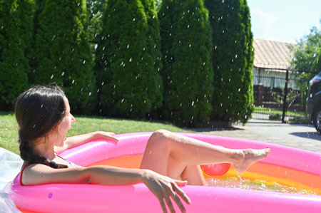 girl splashes water in the pool. High quality photo
