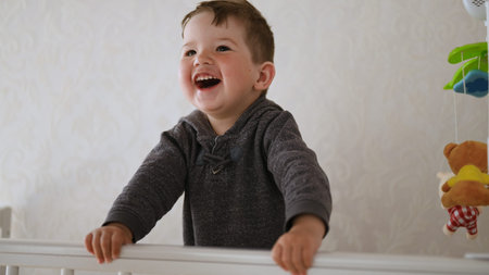 1-2 year old baby having fun in the crib at homeの写真素材