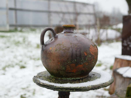 Winter clay jug. Clay jug on wooden fence in winter day.の写真素材