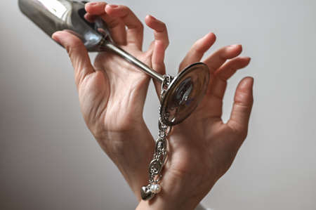 Female hand with jewelry and a glassの写真素材