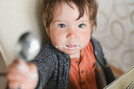 child shows a spoon to the cameraの写真素材