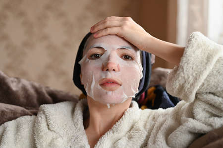 Portrait of a tired girl with a moisturizing face maskの写真素材