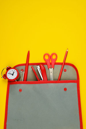 School supplies from a pencil case on a red-yellow background