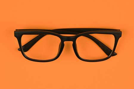 black glasses on an orange backgroundの写真素材