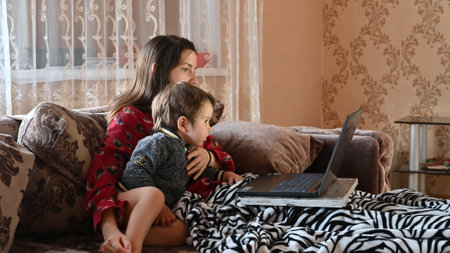 child with mother at home communicate via skype via laptop.の写真素材