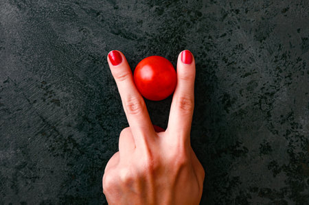 red tomatoes and female hands, top view.