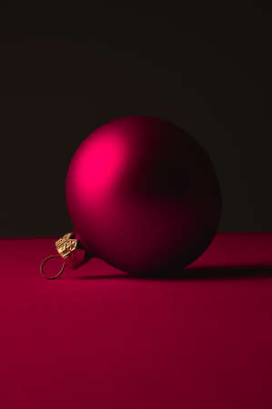 Red Christmas ball lies against a dark backgroundの写真素材