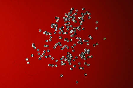 shiny confetti scattered on red backgroundの写真素材