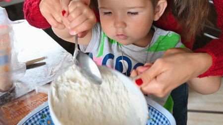 mother and child sift flour through a sieve. High quality photoの写真素材