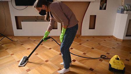 A young girl disinfects the floor with a steam generator. High quality photo