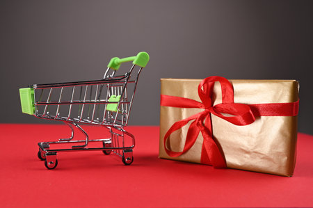 Shopping cart with gift wrapping is tied with a red bow. High quality photoの写真素材