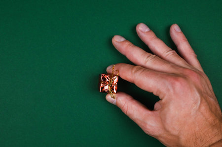 Hand holds a New Year's gift on a green background. High quality photo