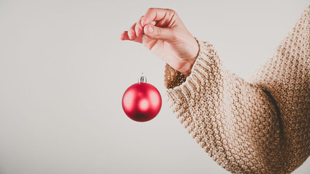 girl holding a red ball in a warm sweater. High quality photo