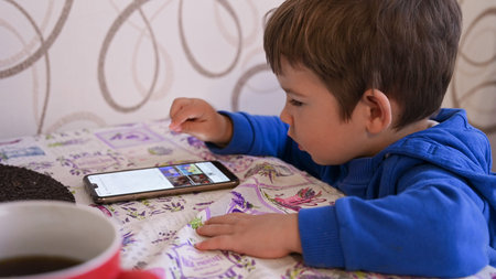 Little child is engaged with a mobile device. High quality photo