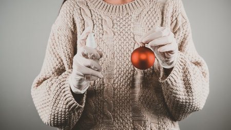 The girl disinfects Christmas toys. Celebrating Christmas in quarantine. High quality photoの写真素材