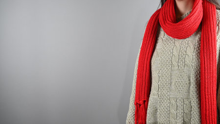 Girl with red scarf and knitted sweater. High quality photoの写真素材