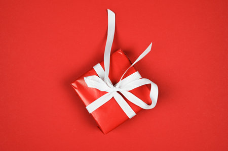 Red gift with white ribbon on red background. High quality photoの写真素材