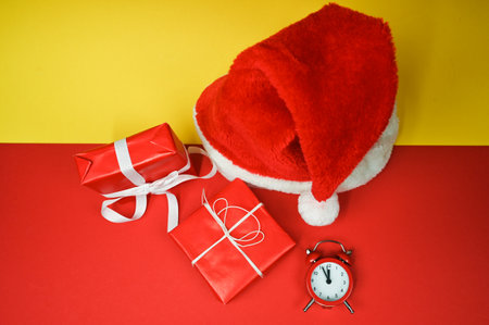 Santa hat and wrapped gift boxes top view. Christmas background in red color. High quality photoの写真素材