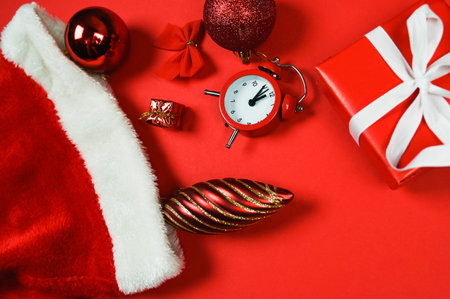 Close-ufp of christmas decorations. Gift box, santa hat, red decorations on red background. ... High...