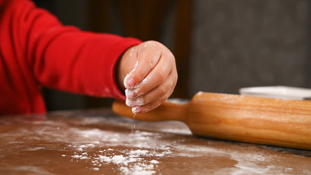 Child's hand pours flour close up. High quality photo