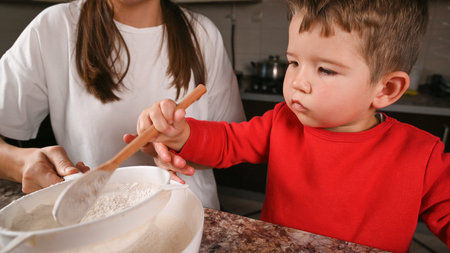 The child and the mother cook together. High quality photo