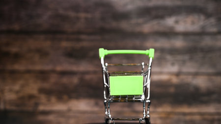 Shopping green trolley on wooden background. High quality photoの写真素材