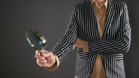 Woman in a suit with a magnifying glass. High quality photoの写真素材