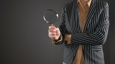 Woman in a suit with a magnifying glassの写真素材