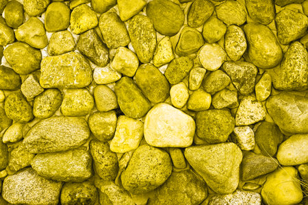 Close-up of natural background from stones. Tinted in illuminating yellow trending color 2021. High quality photoの写真素材