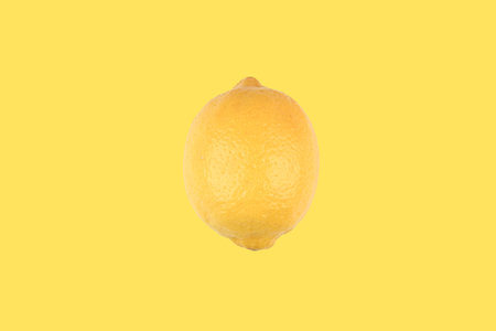 Whole lemon on yellow background. Presentation of trendy color 2021 - yellow. Minimalist, close up image. High quality photoの写真素材