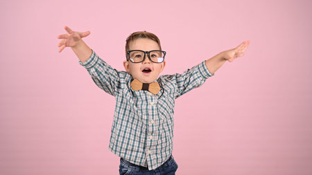 child with glasses, on a pink background. High quality photoの写真素材