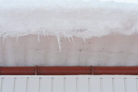 The high roof of a building with a large snowdrift. Danger of snow falling from the roof. High...