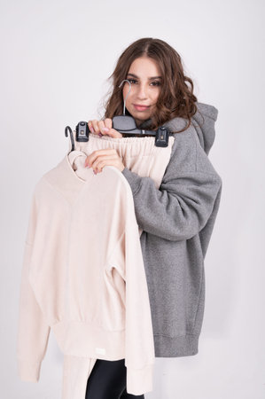 Young woman holding a turtleneck on a hanger, close up portrait with copy space. Shopping and...