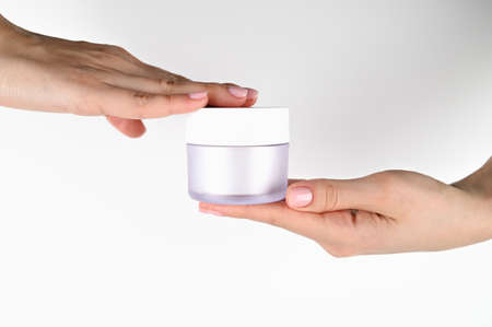 Female hands hold a jar of cream, on an isolated background. High quality photoの写真素材